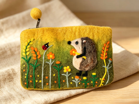 Close-up of handmade wool felt hedgehog coin purse with felted ball zip charm