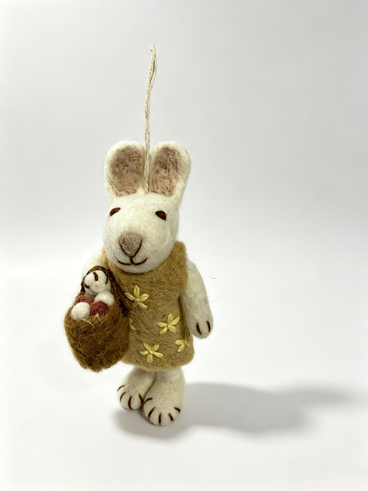 Side view of handmade wool felt bunny rabbit hanging decoration with basket