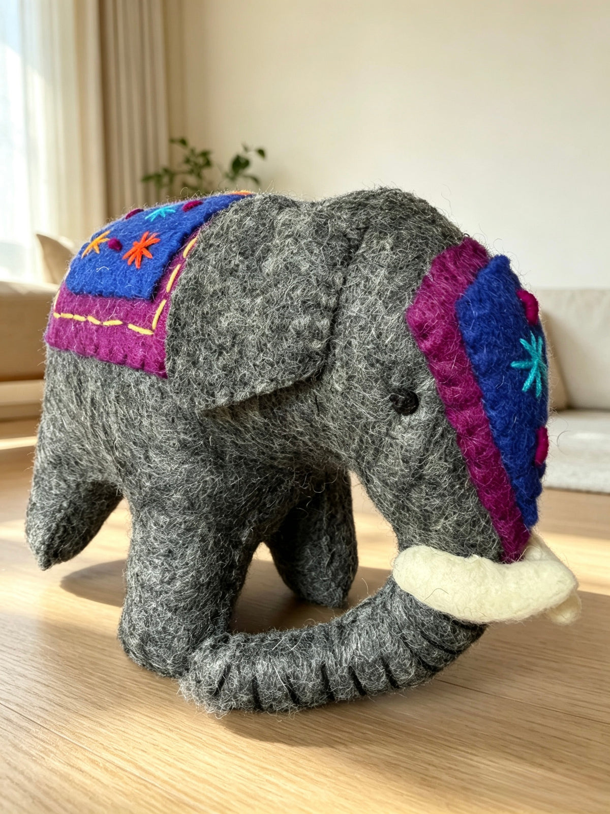 Back detail of handmade wool felt elephant with embroidered blanket and star stitches