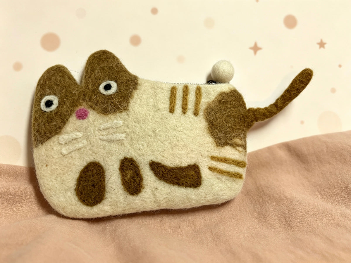 Handmade wool felt tabby cat coin purse on a soft background
