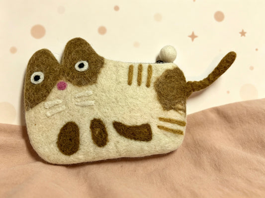 Handmade wool felt tabby cat coin purse on a soft background