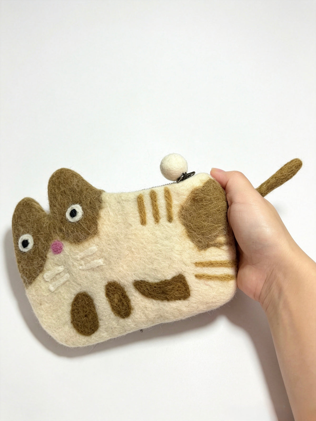 Handmade felt tabby cat coin purse held in a hand