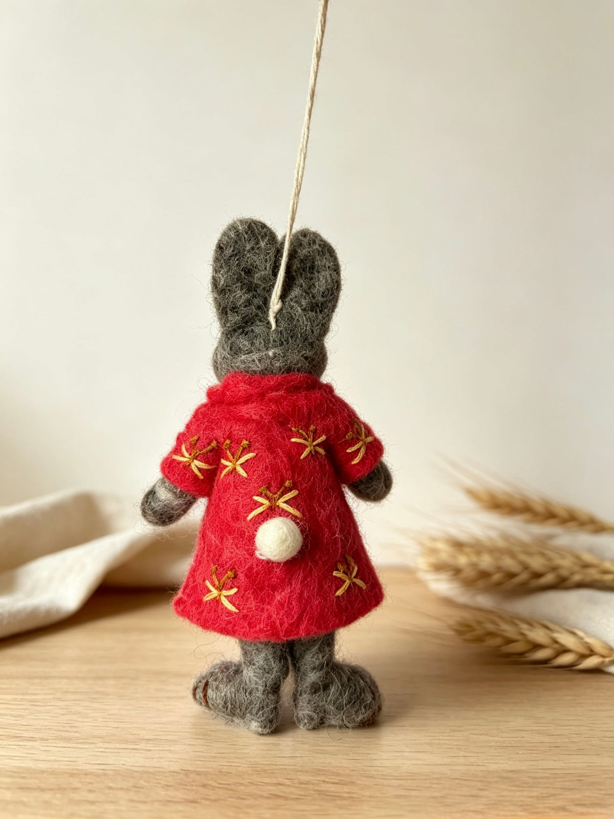 Back view of handmade wool felt bunny rabbit ornament in red floral outfit