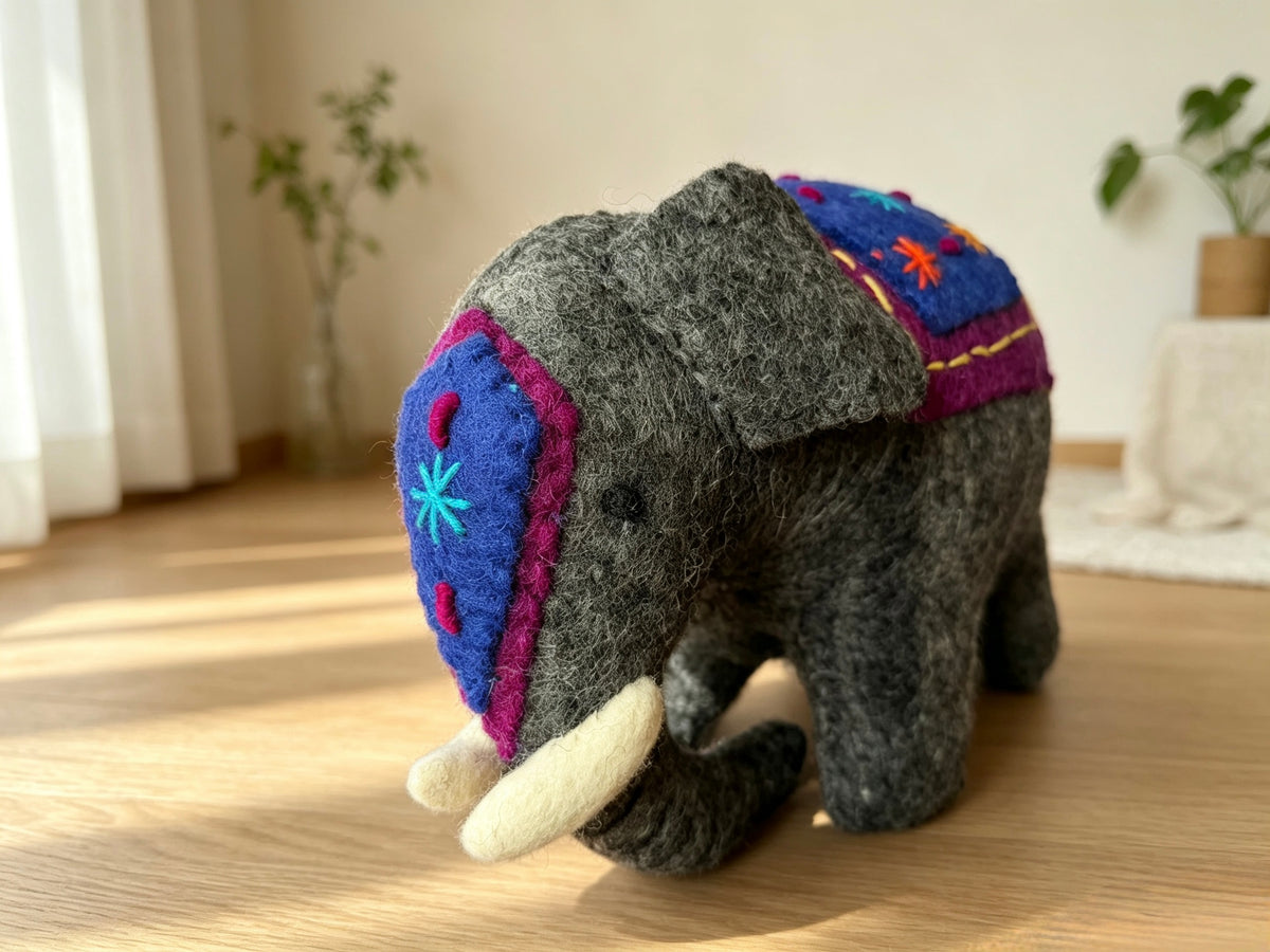 Rear view of handmade wool felt elephant figurine with colourful embroidered blankets