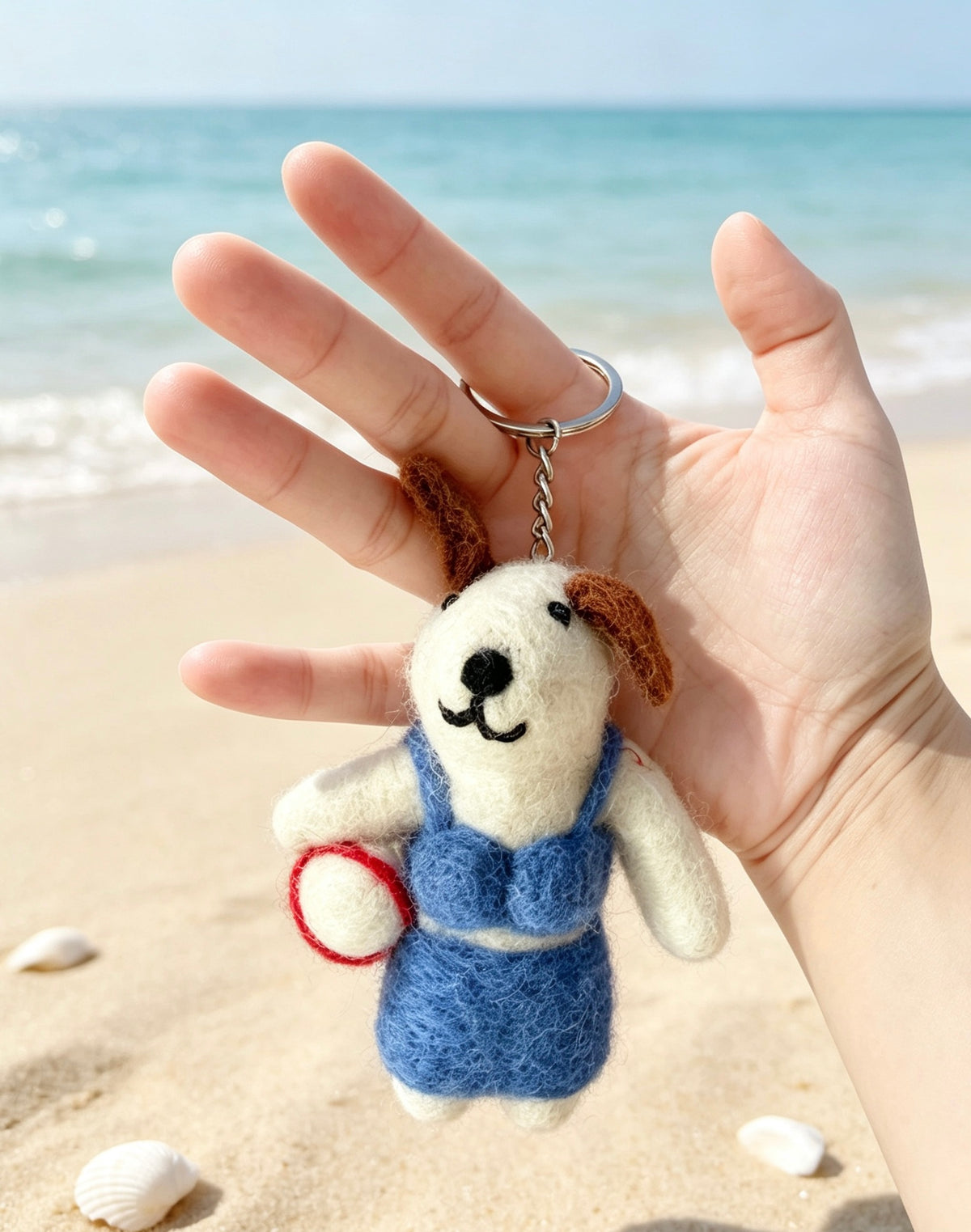 Handmade beach volleyball dog keyring shown in a hand to demonstrate its size