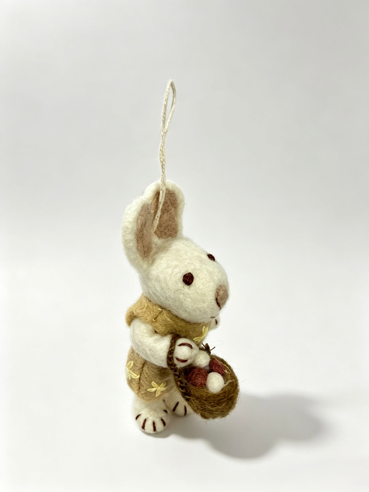 Front view of handmade wool felt bunny rabbit hanging decoration with basket